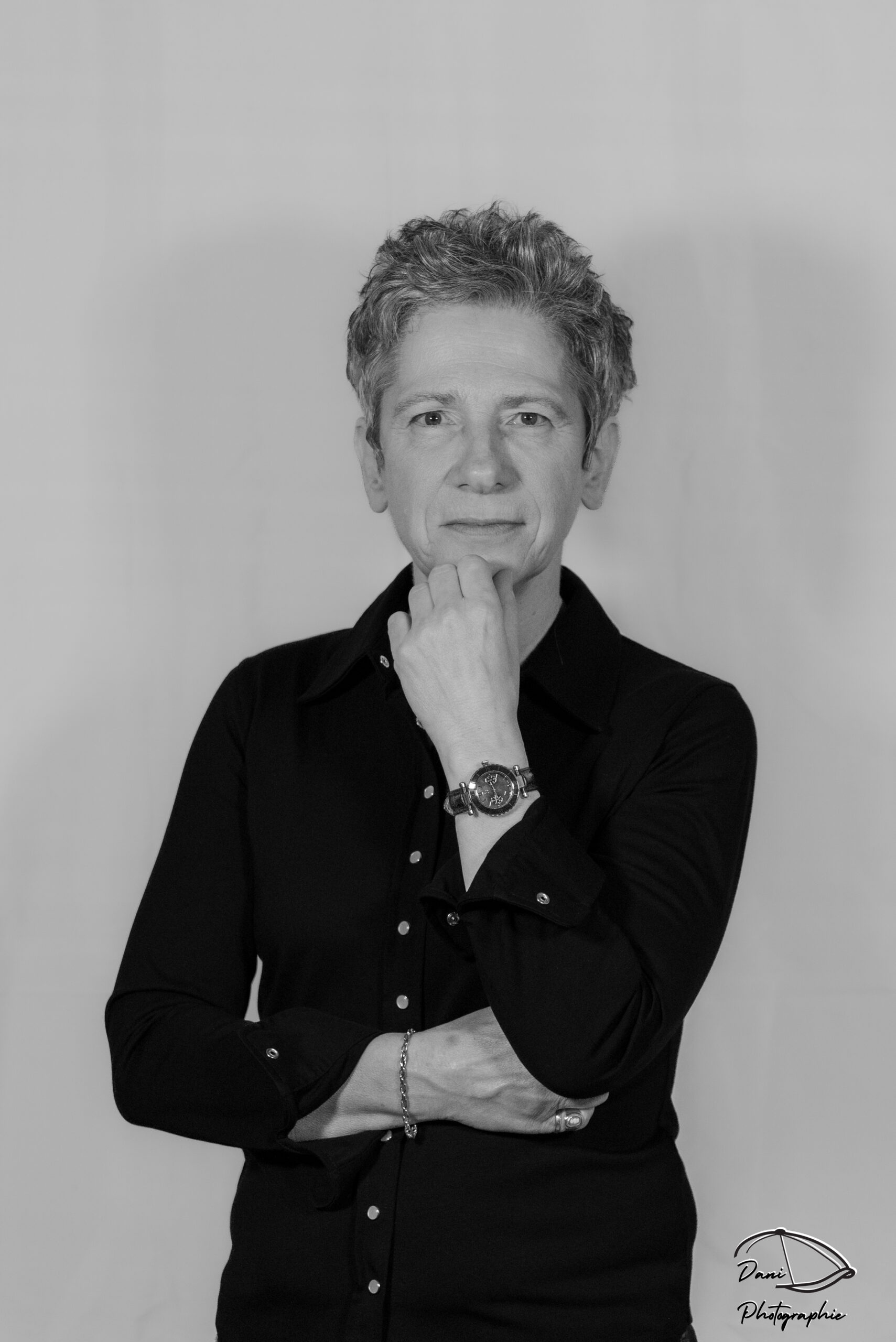 Photo en noir et blanc d'une femme cheffe de cuisine avec une chemise noire