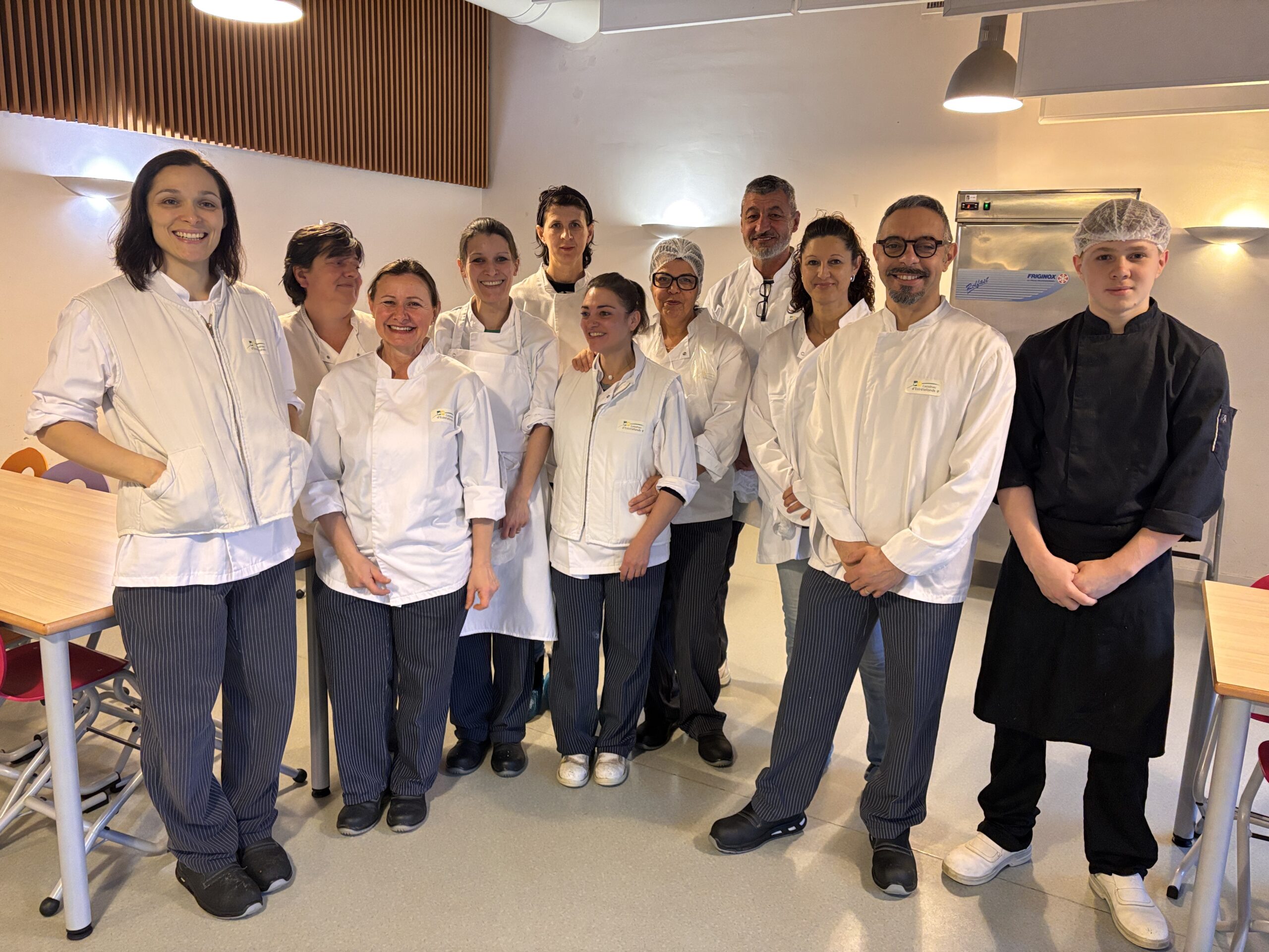 Equipe de cuisine en tenue et souriante