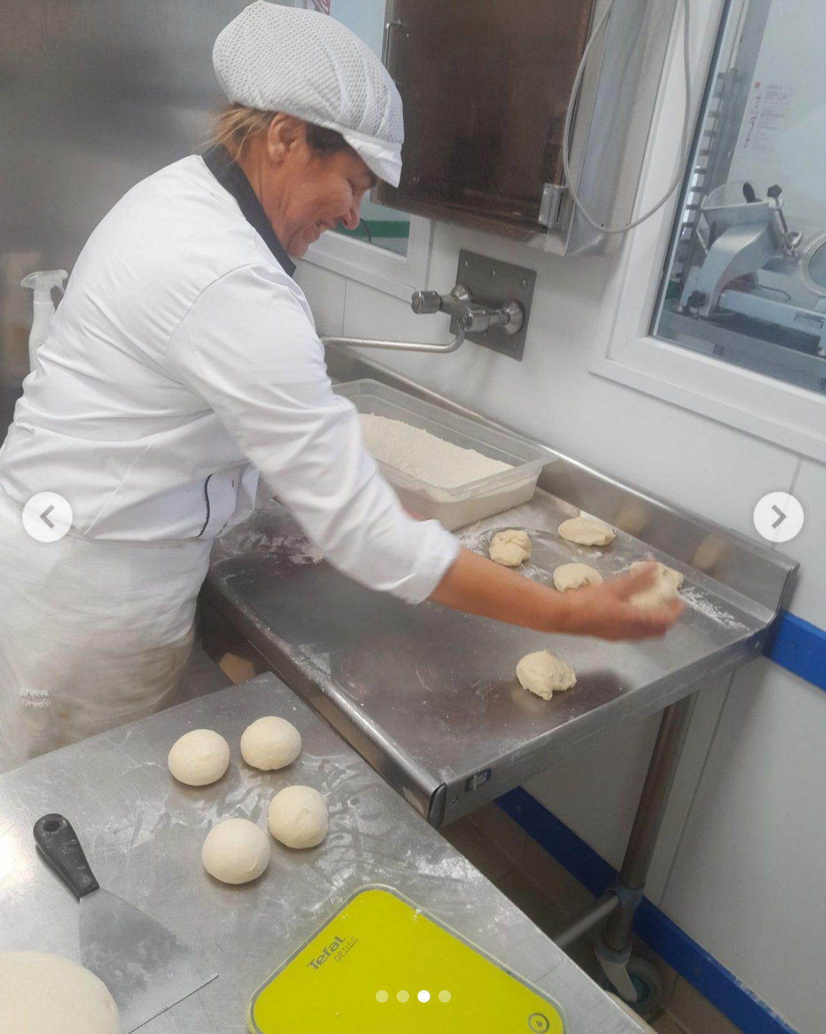 Femme en tenue de cuisine en train de travailler de la pâte à pizza maison